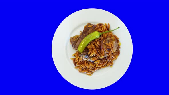 Pepper and side dish on a white rotating plate. Top view from above