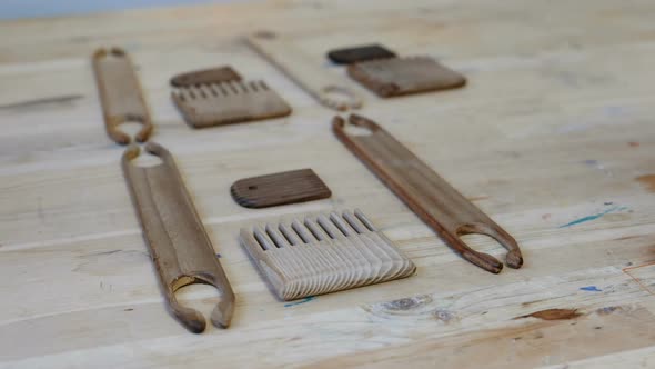 Weaver Puts Tools Scallops and Shuttles on a Wooden Table in the Workshop