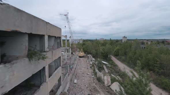 FPV Drone Flies Smoothly Among Abandoned Industrial Buildings and Around an Excavator alt