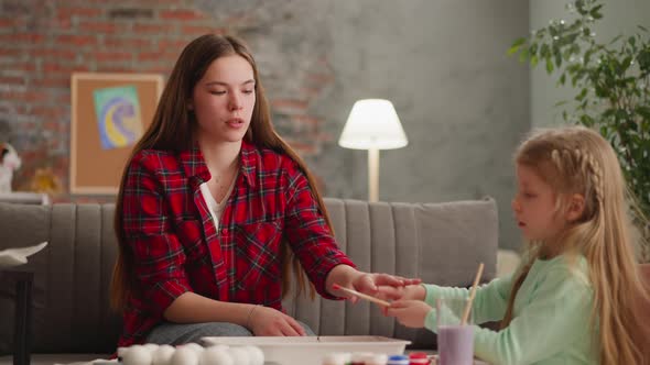 Young Teacher Helps Girl Student Drip Paint for Ebru Art alt