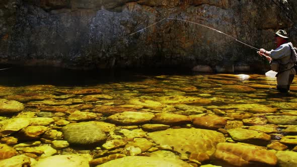 Fisherman fly fishing in river alt
