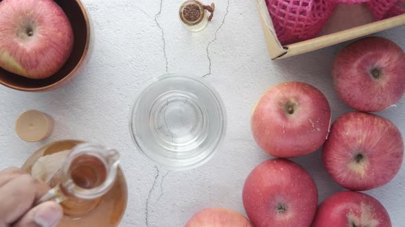 Apple Vinegar in Glass Bottle with Fresh Green Apple on Table alt