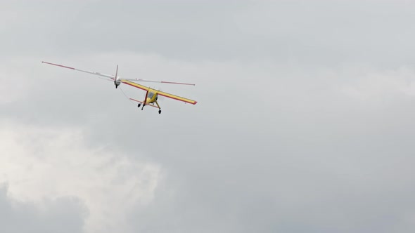 Bright Yellow Plane Pulls Glider on Cable Accelerating It to Required Speed so That Glider Can Fly alt
