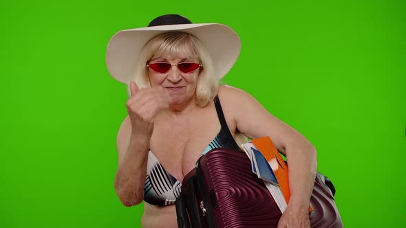 Senior Woman Tourist in Swimsuit with Luggage Passport Tickets Asking to Follow Join on Chroma Key alt