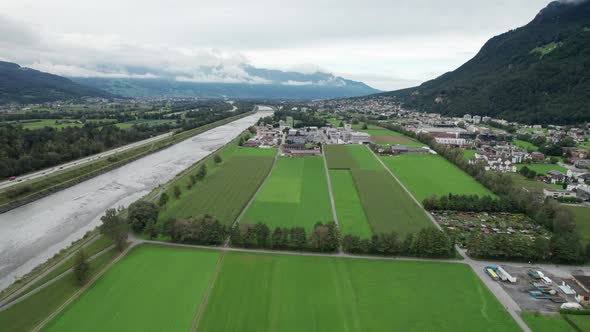 Liechtenstein with Houses on Green Fields in Alps Mountain Valley Aerial View alt