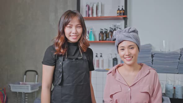 Portrait of Asian hairdresser give treatment service to young girl customer on washing bed in salon. alt