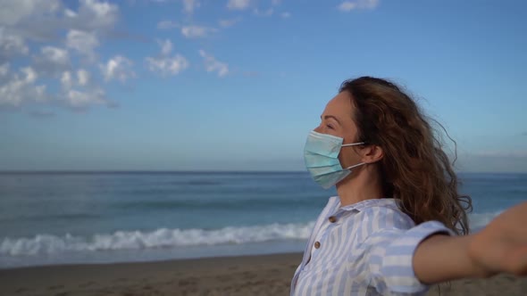 Happy woman wearing medical mask outdoor against blue sky background