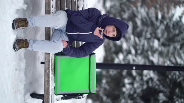 Food Delivery Courier Waiting for a Customer's Address and Records a Voice Message on the Phone alt