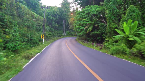 Riding along an asphalt road in the tropics. traveling by car and motorcycle in Asia.  alt