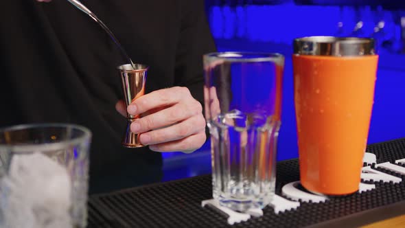 Closeup of Bartender Pouring Drink Into the Glass alt