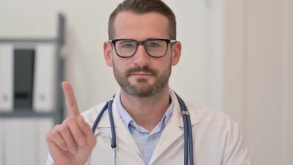 Portrait of Male Doctor Showing No Sign with Finger alt