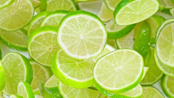 Super Slow Motion Shot of Flying Fresh Lime Slices Towards Camera at 1000Fps alt