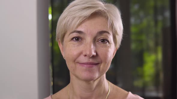 The Joyful Attractive Aged Woman with Brown Eyes and Gold Chain on the Neck