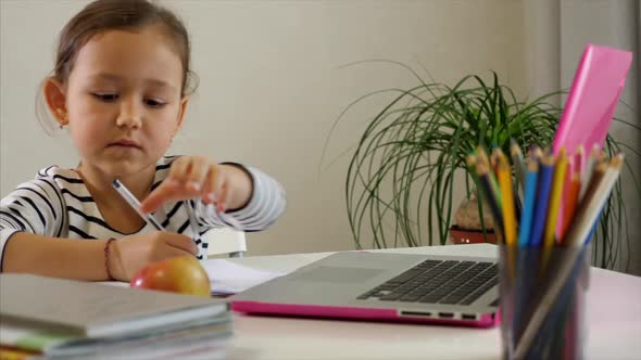Little Child Girl Is Studying Online at Home