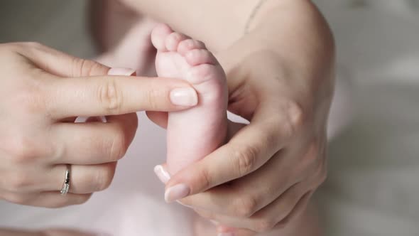 Close Up of Newborn Cute Baby Foot in Mothers Hand