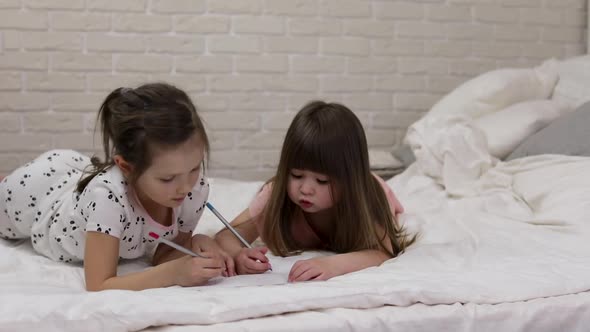 Kids Drawing Pictures While Lying on Bed