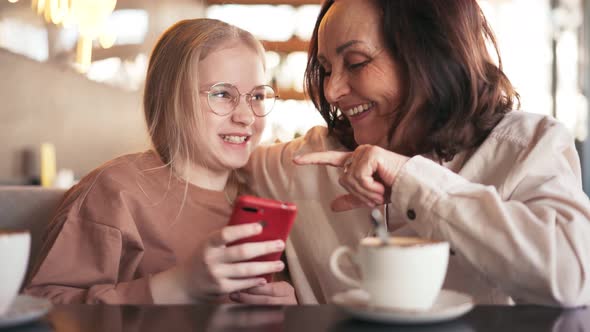 Happy Grandmother and Cute Granddaughter Using Mobile Phone Together alt