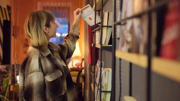 Portrait of Clever Student with Open Book Reading It in College Library alt