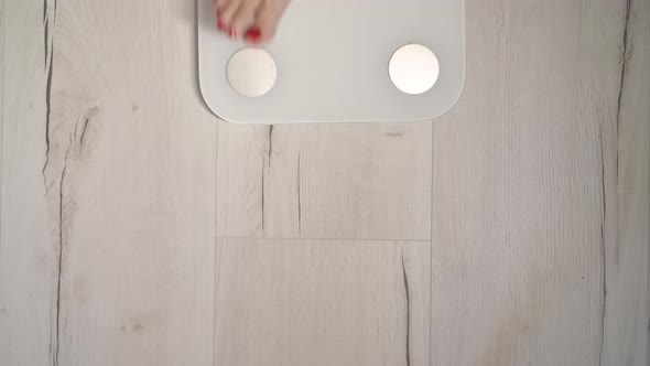 Young Woman Stands on a White Electronic Scale