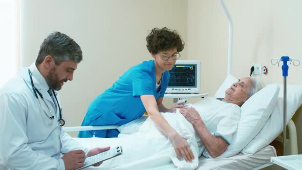 Nurse covering old woman with blanket