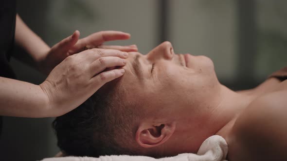 Manipulative Therapy for Healing Headache Man is Relaxing in Massage Parlor of Osteopathy Clinic alt