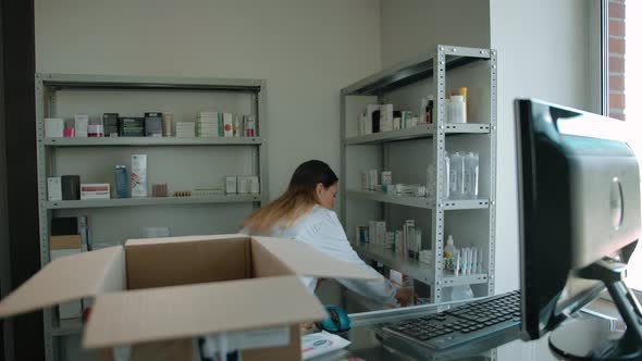 Young Caucasian Woman Packing Up Medicine Stuff in Box for Online Customer alt