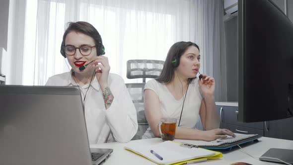 Two Female Call Center Agents Working on Their Computers alt