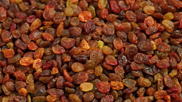 Looped Spinning Full Frame Background of Yellow and Brown Raisins Pile