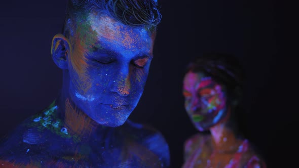 Couple with UV Drawings on the Skin in Dark Under the Light of Fluorescent Lamps alt