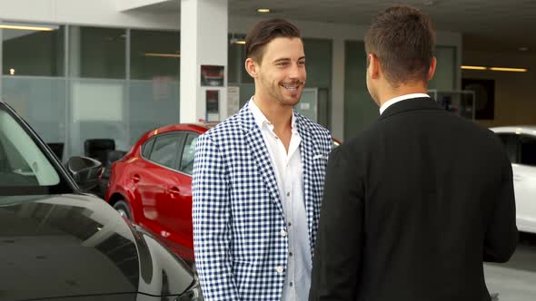 The Happy Buyer and the Seller Makes a Deal of Buying a Car