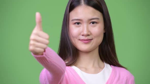 Young Beautiful Asian Woman Giving Thumbs Up