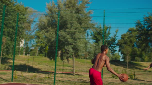 Streetball Player Making Slam Dunk Over Defender alt