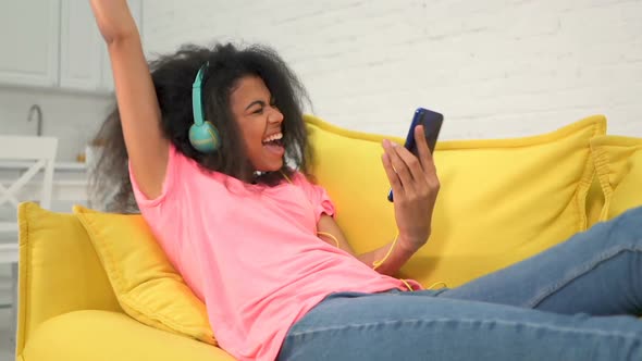 Woman lying on the sofa and listening to music.