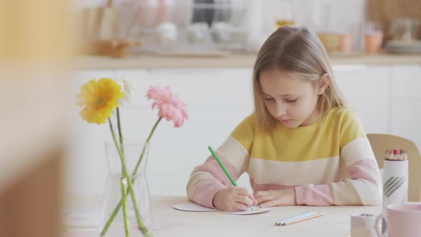Kid Drawing Using Coloured Pencils alt