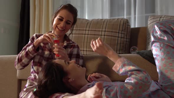 Twins Sisters Having Fun Blowing Bubbles Wearing Pretty Pajamas alt