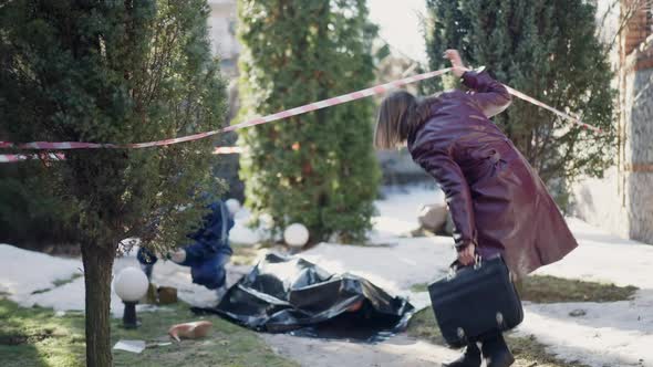Private Investigator Entering Crime Scene with Forensics Scientist Examining Corpse alt