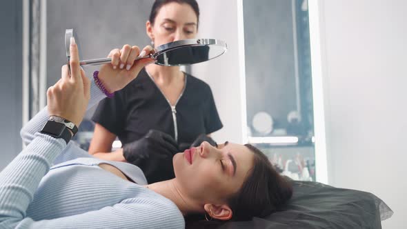 Permanent Makeup Master Prepares Woman Client for Eyebrow Microblading Procedure alt