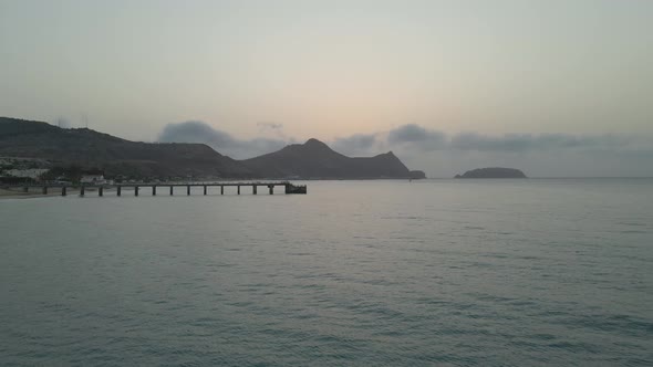Drone flies towards the point of the boardwalk on a cool grey morning with low hanging clouds. alt
