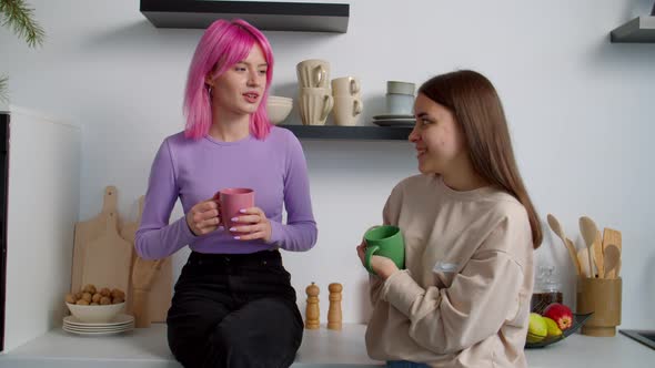 Cheerful Lovely Female Roommates Chatting Over Coffee in Kitchen at Dorm alt