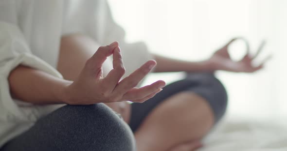 Beautiful Asian healthy pregnant woman practicing yoga in the bedroom.