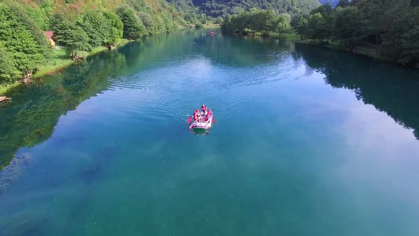 Aerial view of rafters paddling through still water of Una river in Bosnia alt