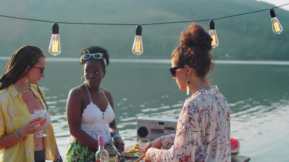 Girls Cooking Food for Outdoor Party on Lake Pier alt