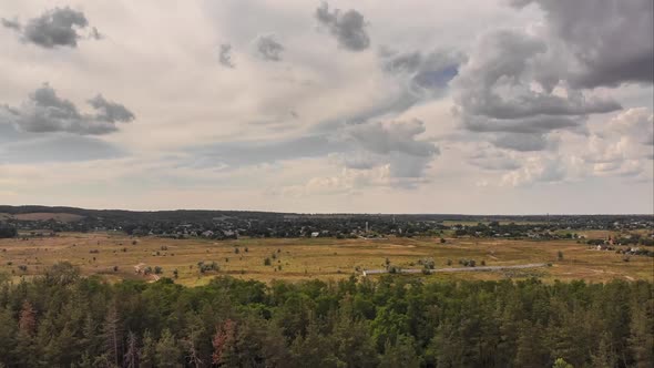 Hyperlapse Aerial Drone View Over Green Forest with Moving Clouds in Blue Sky alt