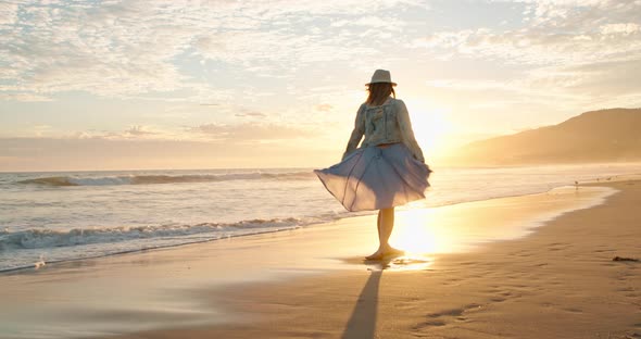 Cheerful Beautiful Woman Is Dancing on the Beach in Golden Sunset Light. USA alt
