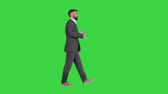 Bearded Businessman Walking and Explaining Something on a Green Screen, Chroma Key. alt