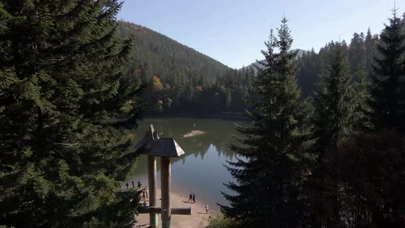 Drone Footage of a Synevyr Lake in Ukraine Autumn Shot Through the Trees