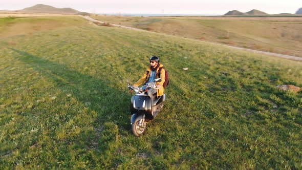 A Traveler on a Moped Admires the Sunset From a Hillside Shooting From a Drone The Last Sun's Rays