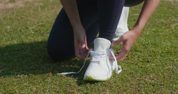 Woman fix shoelace at park