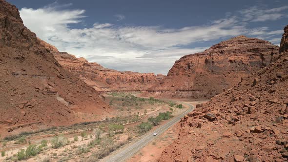 Aerial view of car driving on the highway through a Utah desert canyon alt