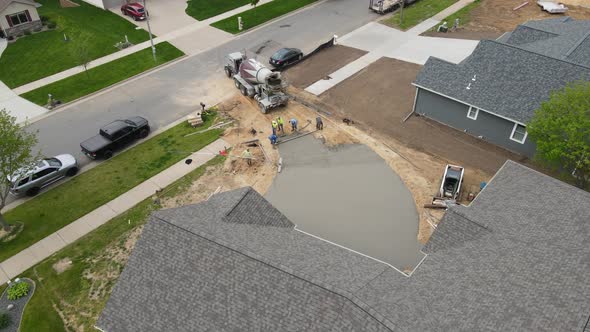 Overhead view of concrete driveway being completed at a new home construction project in spring.